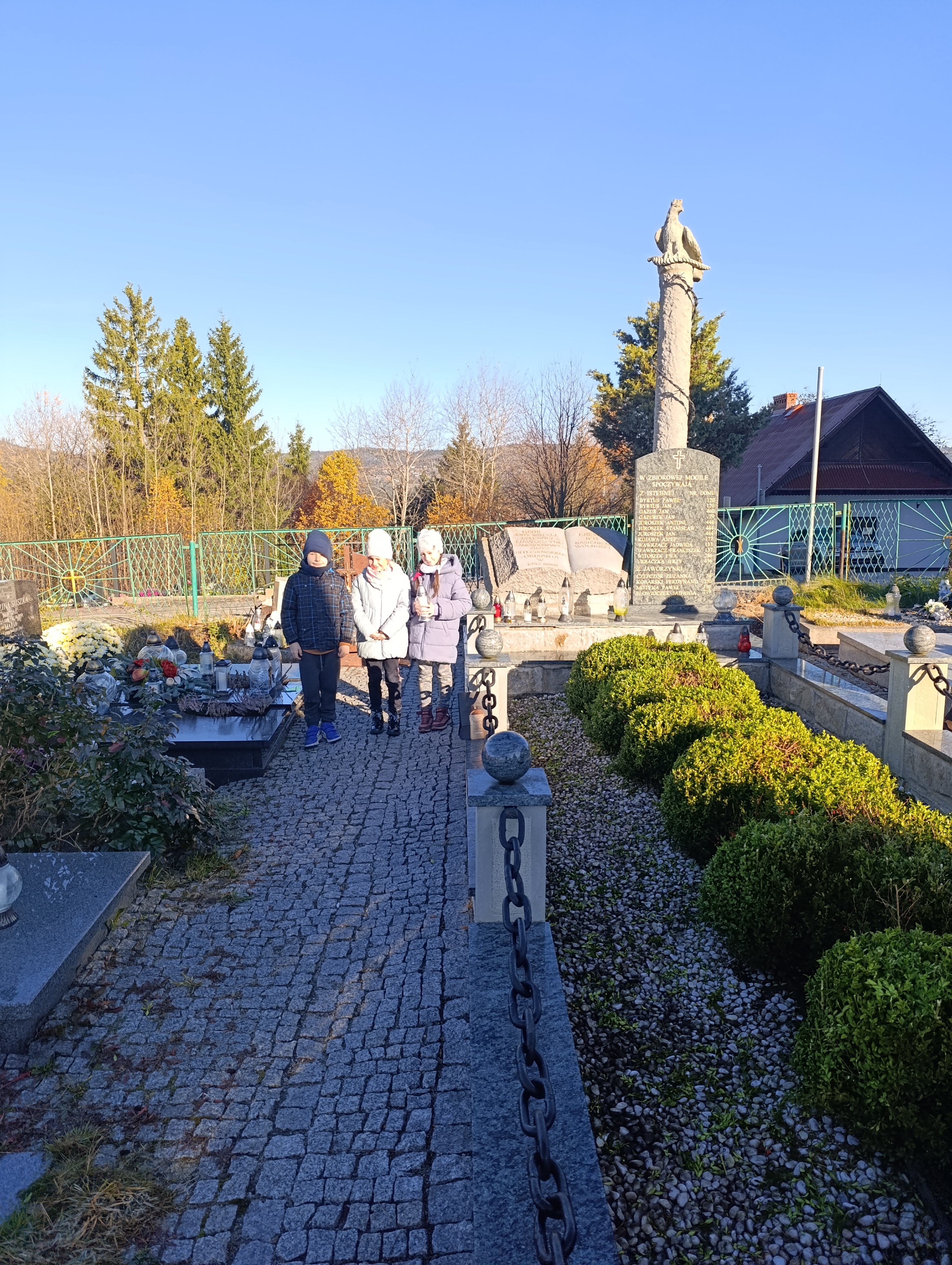 Dzień Wszystkich Świętych - kl.3 dzieci z kl. 3 zapalają znicz na zbirowej mogile