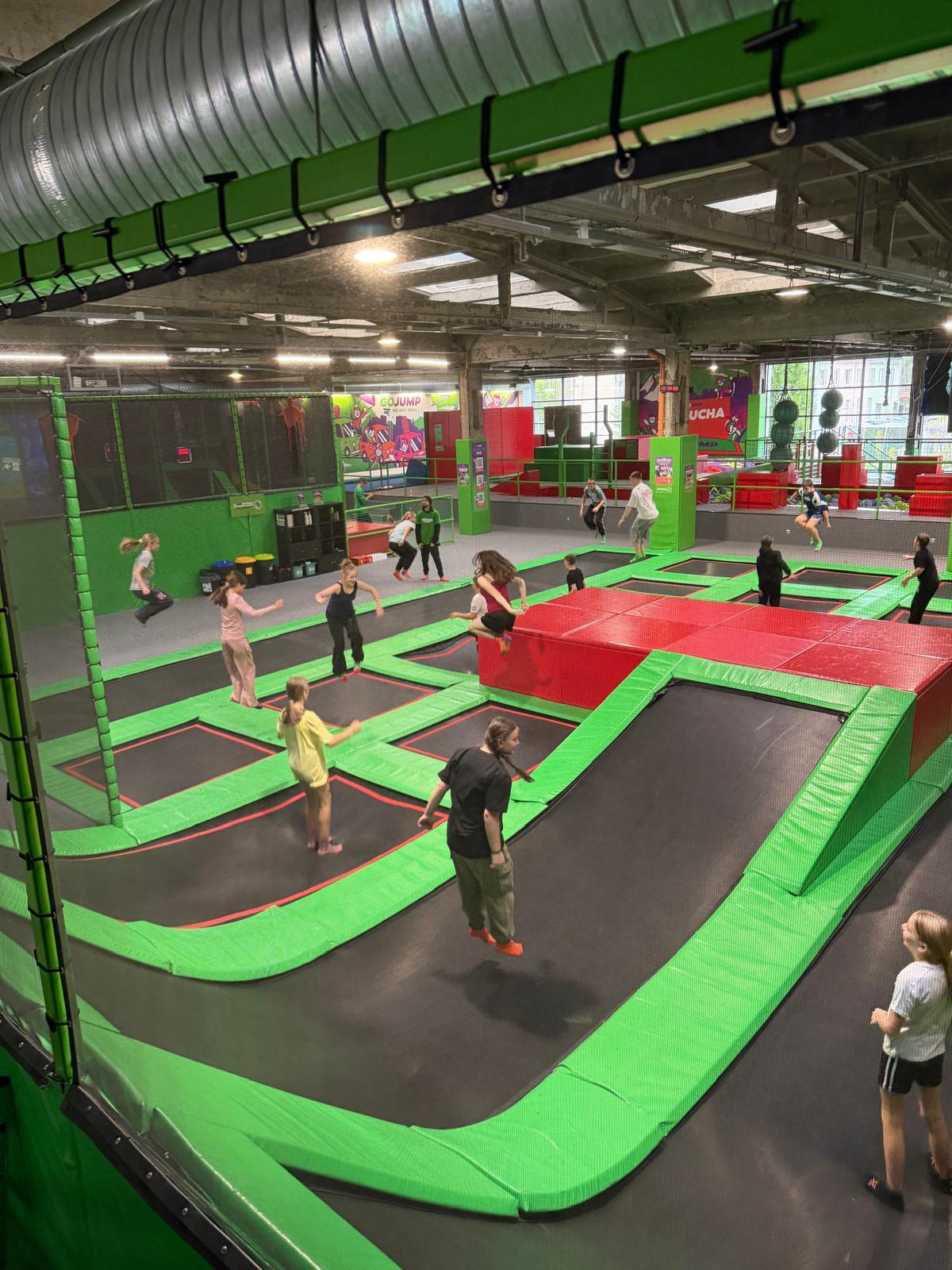 dzieci skaczące na trampolinach